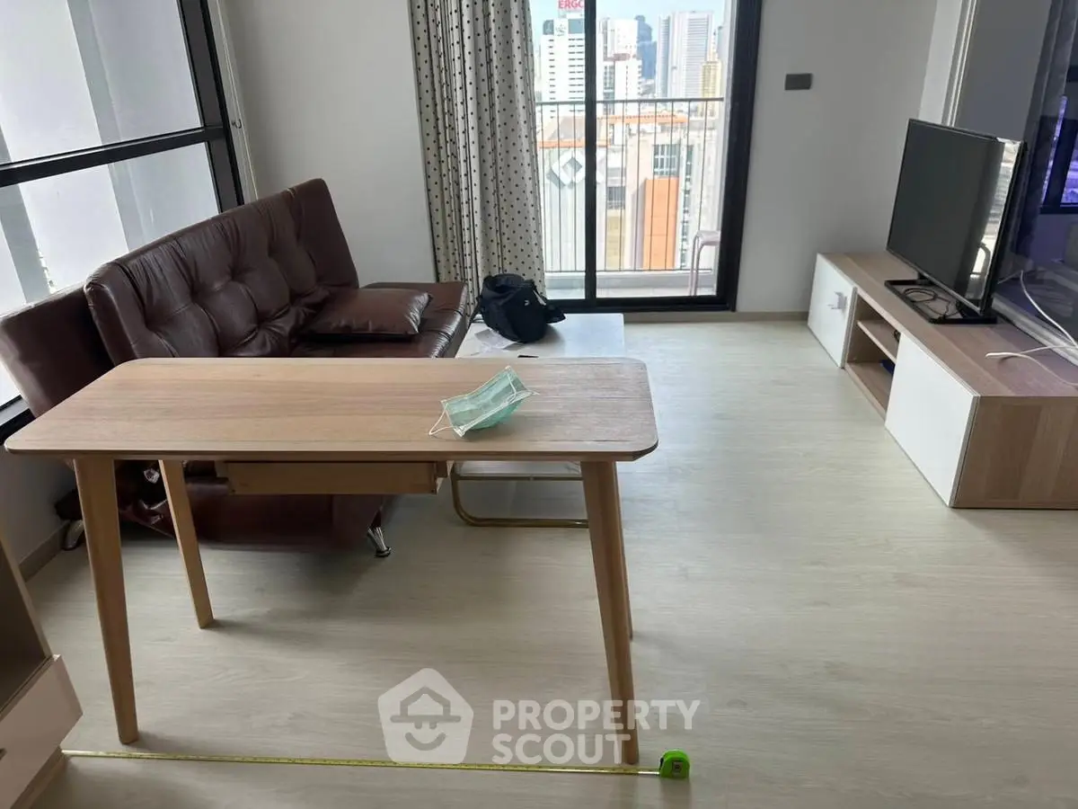 Modern living room with city view, featuring sleek furniture and natural light.