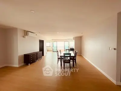 Spacious open-plan living and dining area with wooden flooring and natural light.