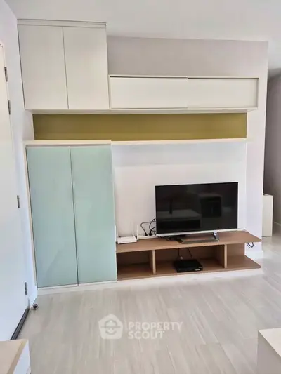 Modern living room with sleek TV unit and storage cabinets, perfect for stylish urban living.