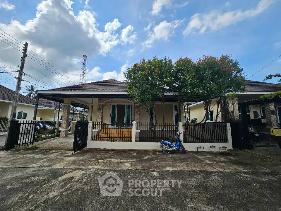 Charming single-story home with spacious driveway and lush greenery