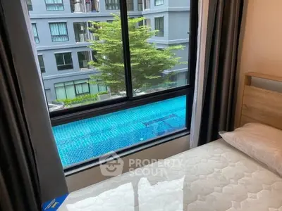 Modern bedroom with pool view in urban apartment complex