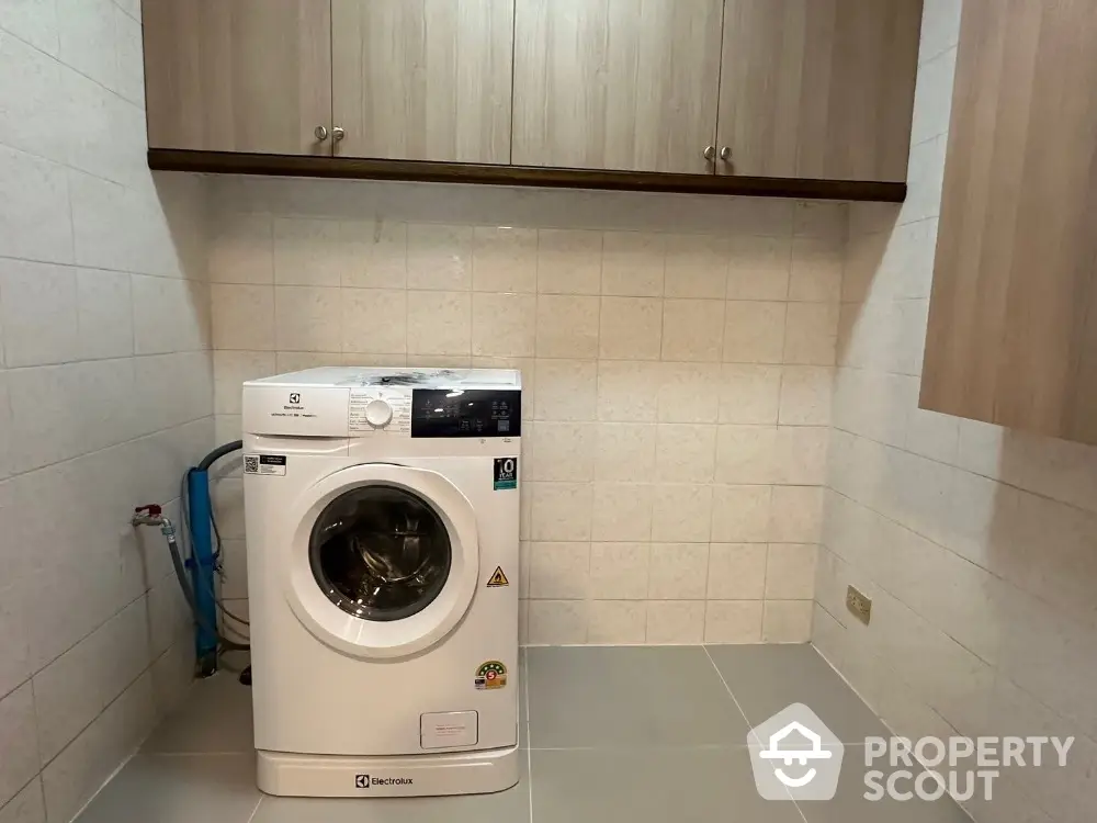 Modern laundry room with washing machine and storage cabinets