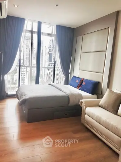 Luxurious bedroom with city view, elegant decor, and natural light in modern apartment.