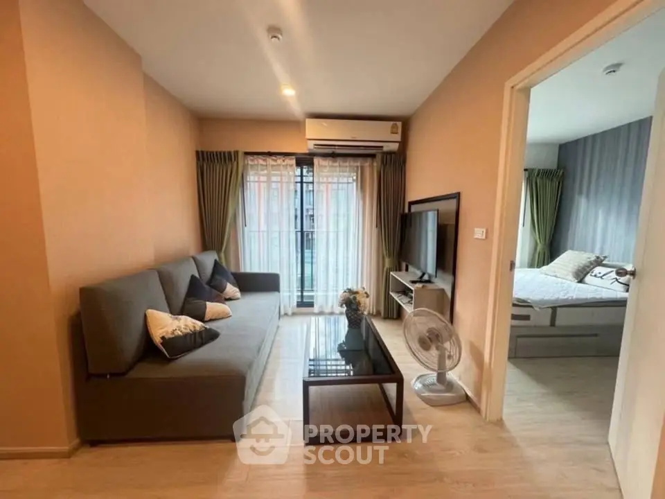 Modern living room with cozy sofa, TV, and access to bedroom in stylish apartment.