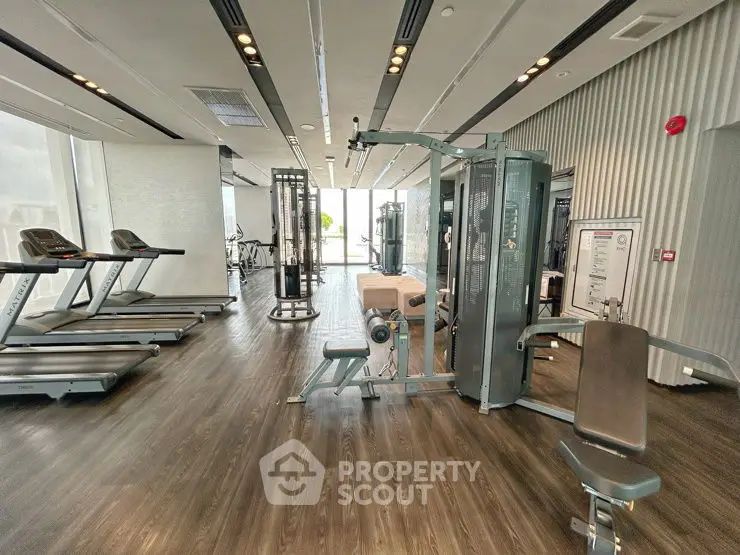 Spacious modern gym with state-of-the-art equipment and natural lighting.
