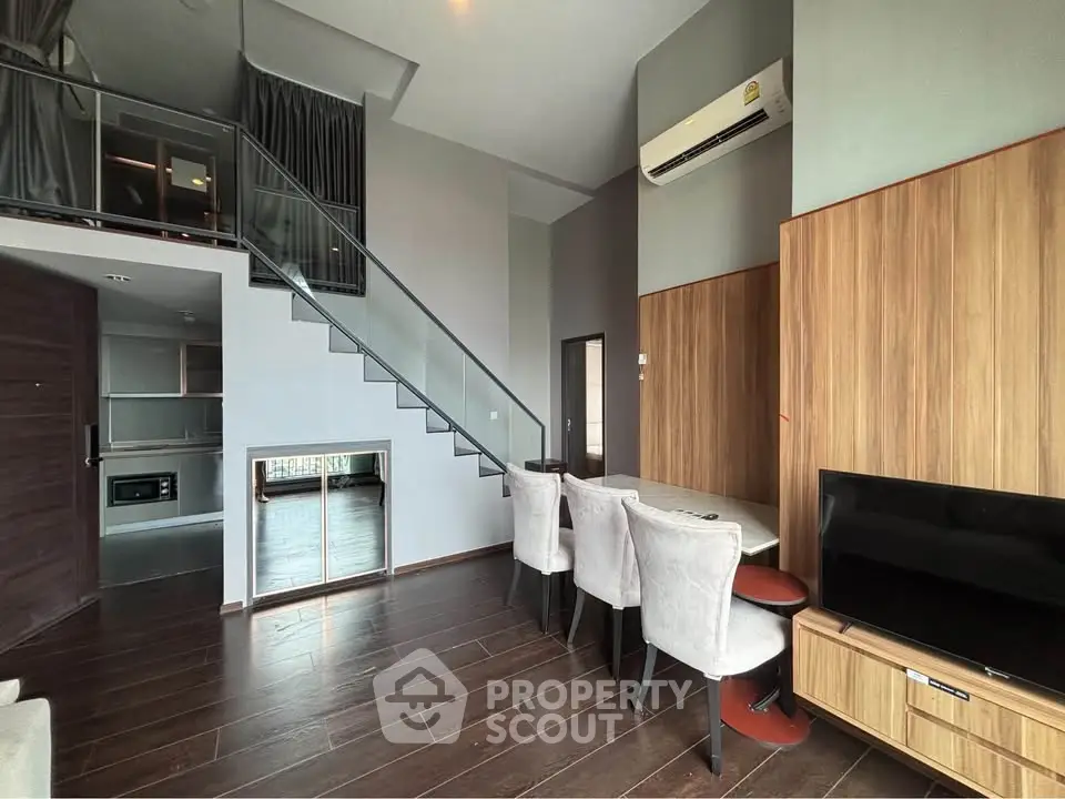 Modern loft apartment with mezzanine, sleek wooden floors, and stylish dining area.