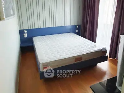 Spacious bedroom with modern design and large window for natural light.