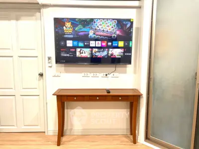 Modern living room with wall-mounted TV and elegant wooden console table.