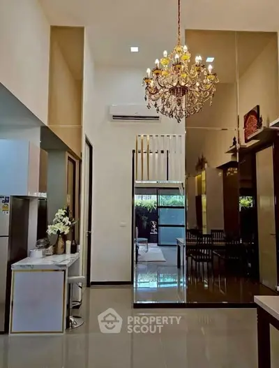 Luxurious high-ceiling living room with elegant chandelier and modern decor