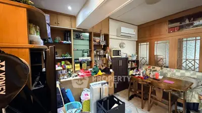 Cozy living room with wooden cabinets and dining area, featuring air conditioning and ample storage.