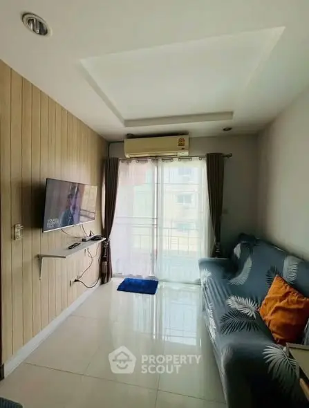 Modern living room with sleek design, wall-mounted TV, and large window for natural light.