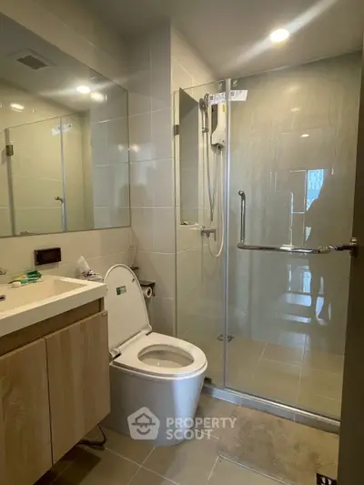 Modern bathroom with glass shower and sleek fixtures in a contemporary apartment.