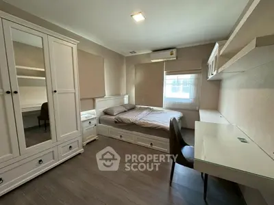 Modern bedroom with sleek furniture and ample storage in a stylish apartment.