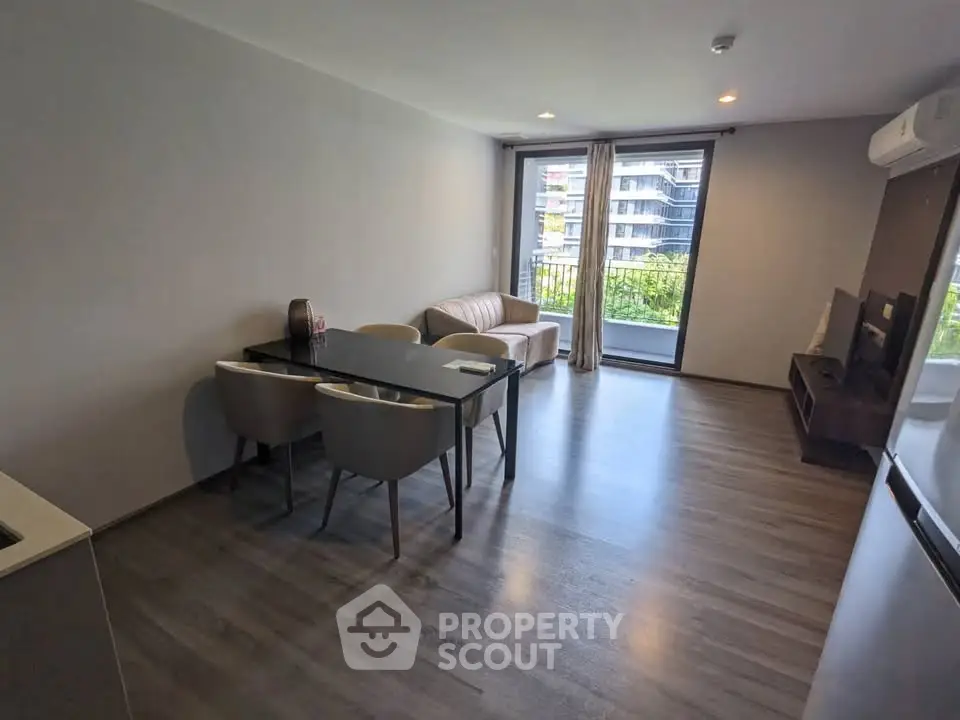 Modern living room with sleek furniture and balcony view in a contemporary apartment.