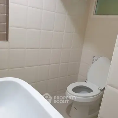 Modern bathroom with white tiled walls and toilet
