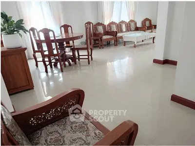 Spacious living room with elegant wooden furniture and large windows for natural light.