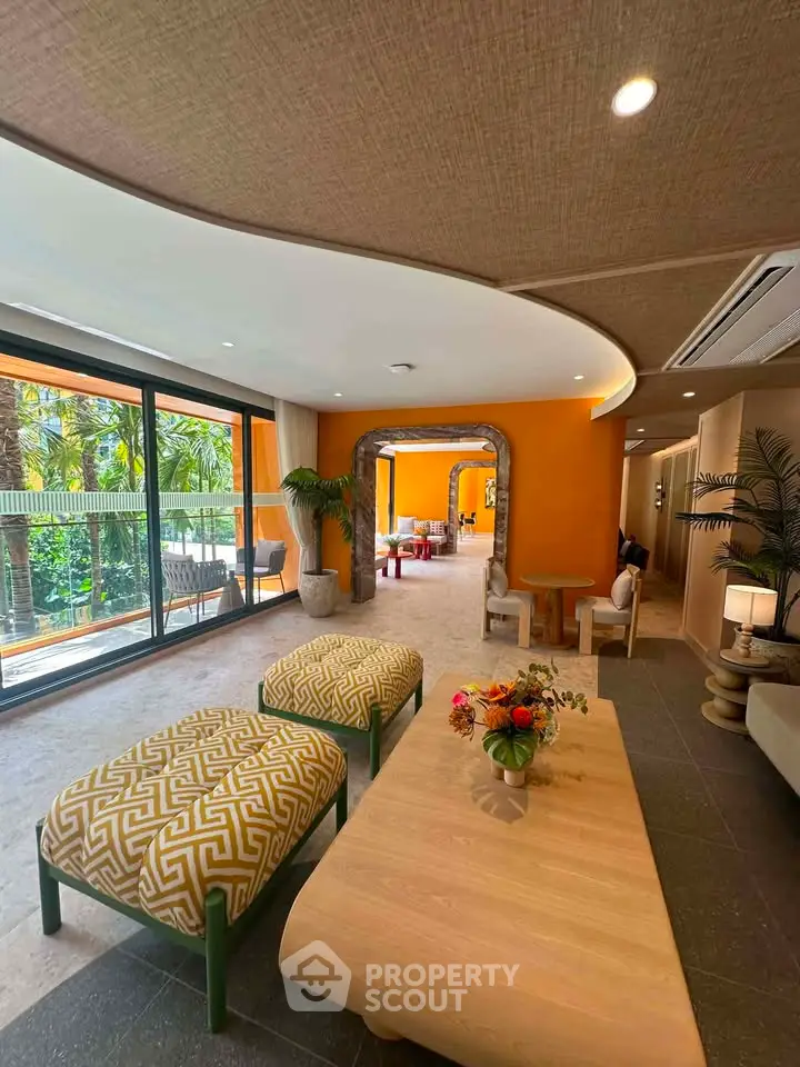 Luxurious living room with modern decor and large windows overlooking lush greenery.