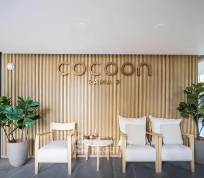Modern lobby area with stylish wooden paneling and cozy seating at Cocoon Rama 9.