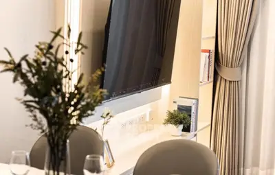 Elegant dining area with modern decor and large TV in stylish apartment