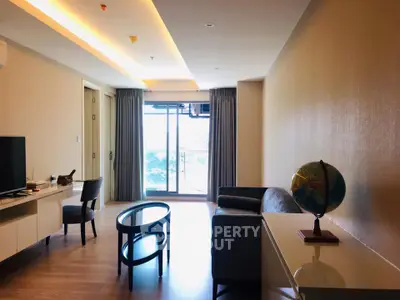 Modern living room with balcony view, stylish furniture, and natural light