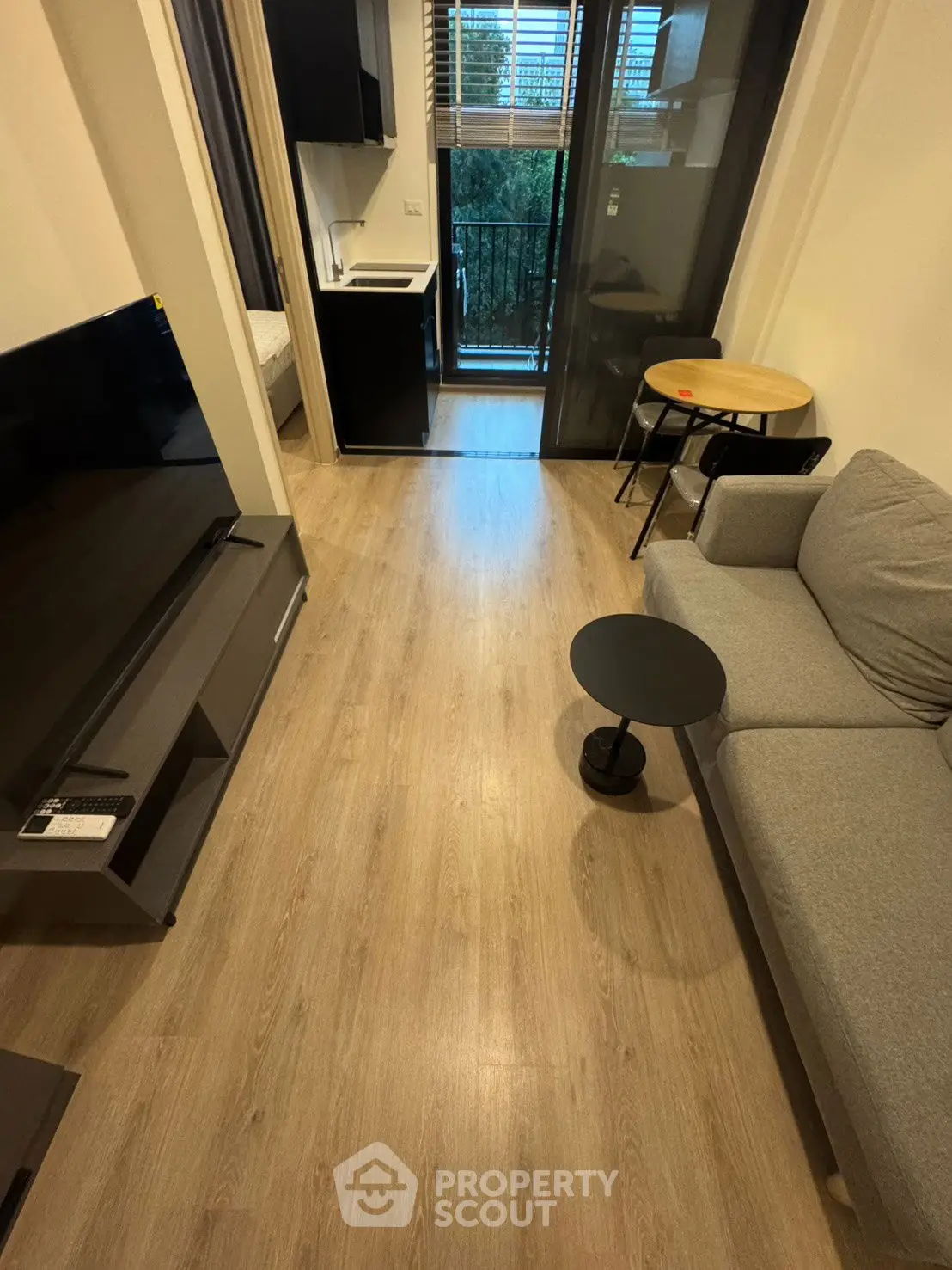 Modern living room with sleek furniture and a view of the balcony, ideal for urban living.