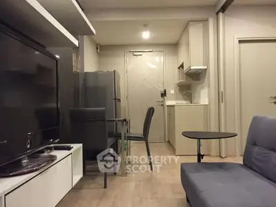 Modern compact living room with kitchenette and dining area, featuring sleek furniture and neutral tones.