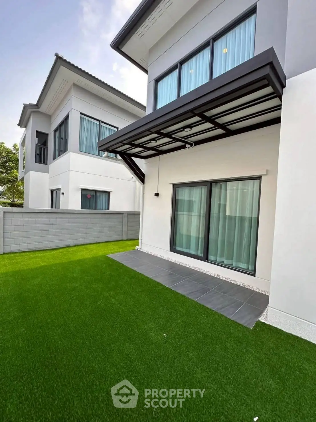 Modern two-story house with sleek design and lush green lawn, perfect for family living.