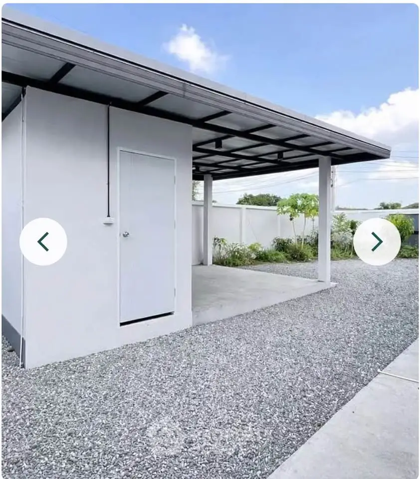 Modern minimalist carport with sleek metal roof and gravel driveway, perfect for contemporary homes.