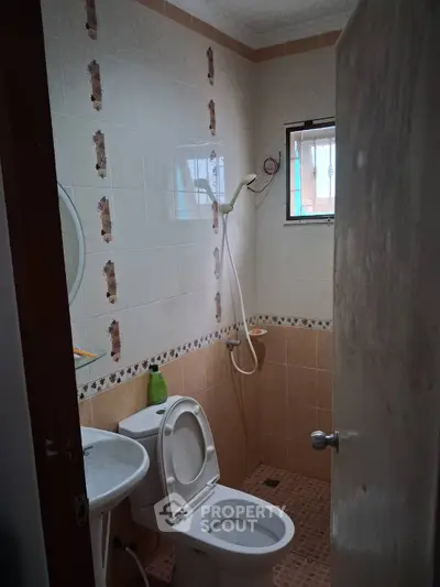 Compact bathroom with shower and toilet in cozy real estate property