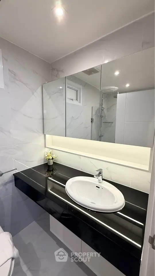 Modern bathroom with sleek black countertop and elegant fixtures