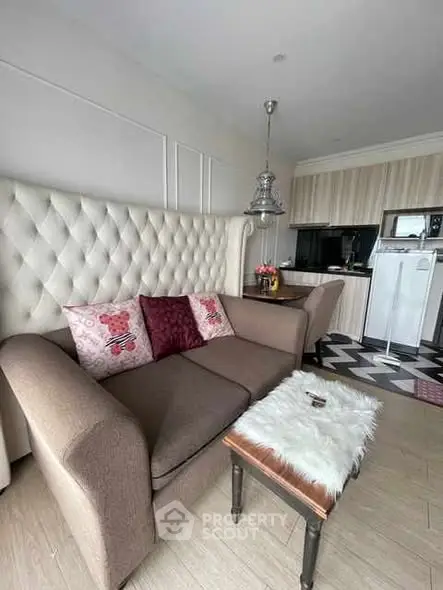 Chic living room with plush sofa and modern kitchen in open layout apartment.