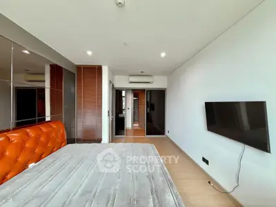 Spacious modern bedroom with sleek design and wall-mounted TV