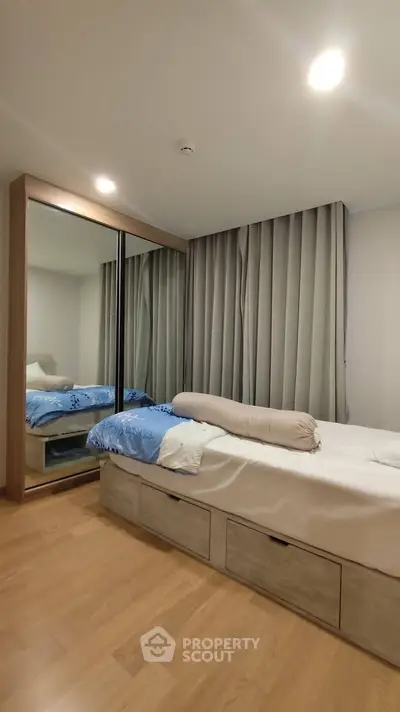 Modern bedroom with mirrored wardrobe and cozy bed in stylish apartment.