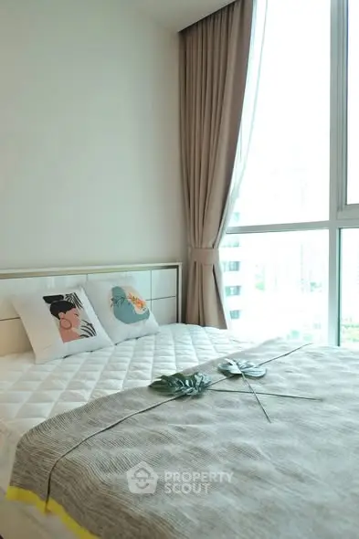 Bright and cozy bedroom with large window and stylish decor in modern apartment.
