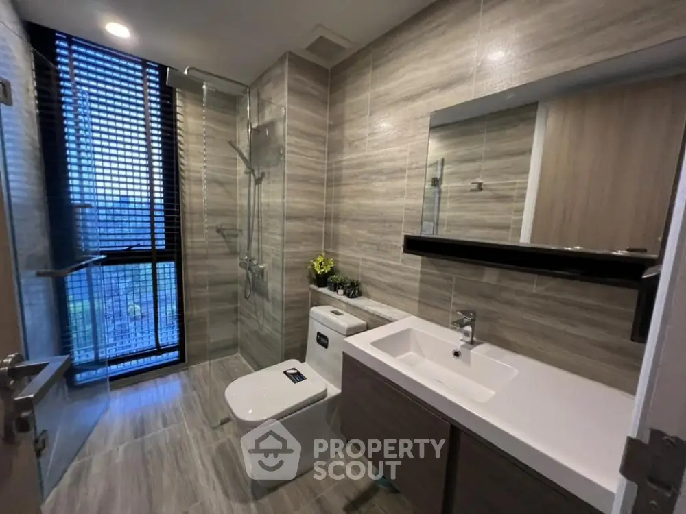 Modern bathroom with sleek fixtures and large window for natural light.