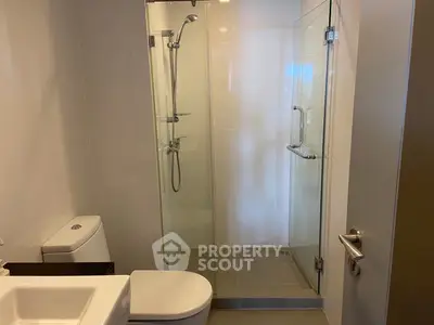 Modern bathroom with glass shower and sleek fixtures in a contemporary home.