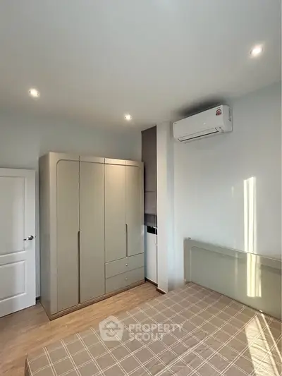 Modern bedroom with sleek wardrobe and air conditioning unit