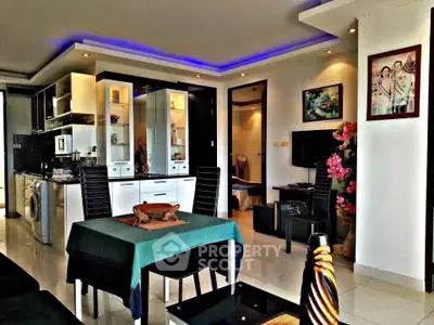 Modern open-plan living room with stylish kitchen and dining area, featuring sleek furniture and ambient lighting.