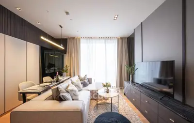 Modern living room with stylish decor, large TV, and elegant dining area, perfect for contemporary urban living.