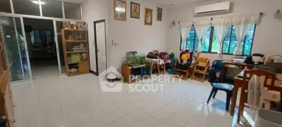 Spacious living room with tiled floor and large windows, perfect for family gatherings.