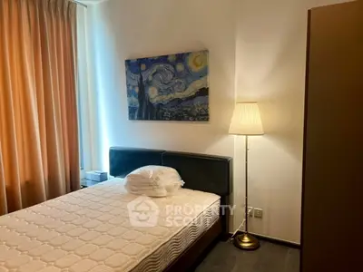 Cozy bedroom with modern decor and stylish artwork, featuring a comfortable bed and elegant lighting.