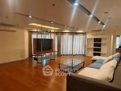 Spacious modern living room with hardwood floors and large windows