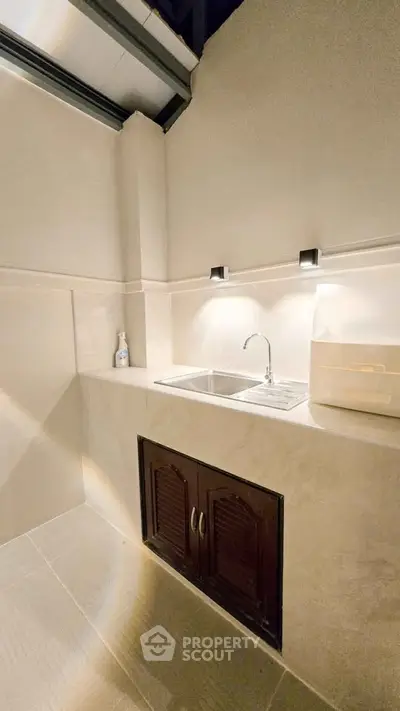 Modern minimalist kitchen with sleek sink and under-cabinet lighting