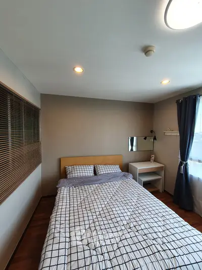 Cozy bedroom with modern decor and ample natural light, featuring a comfortable bed and stylish furnishings.