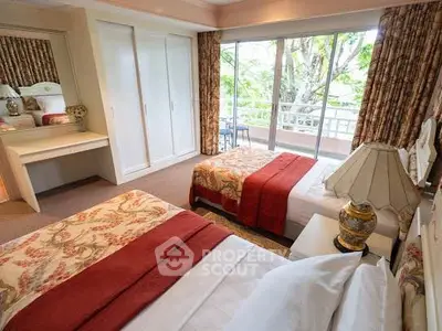 Spacious bedroom with twin beds and balcony view, perfect for relaxation.