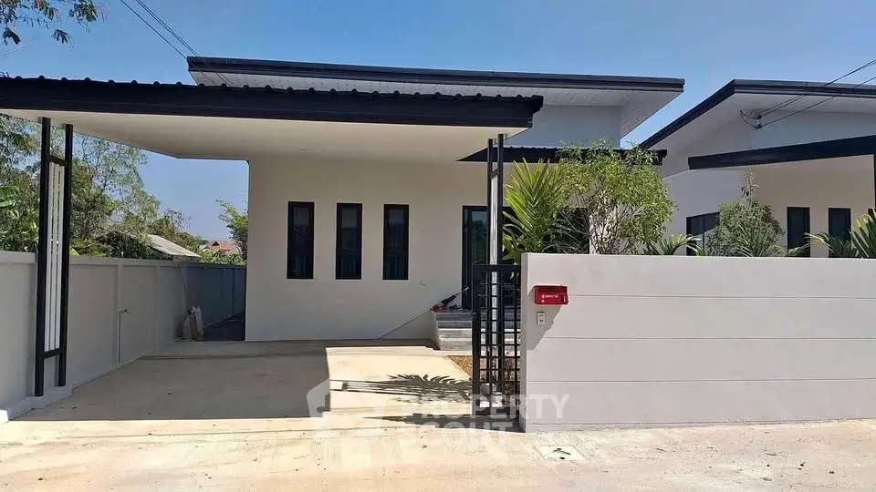 Modern minimalist house exterior with sleek design and gated entrance.