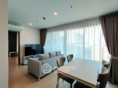 Spacious modern living room with large windows and elegant dining area in a stylish apartment.