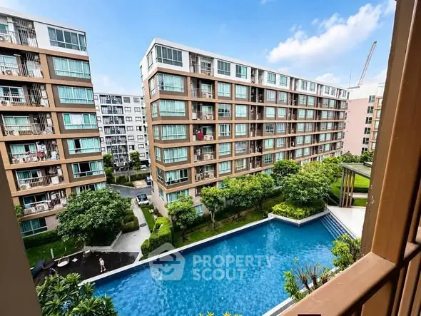Modern apartment complex with pool view and lush greenery, perfect for urban living.
