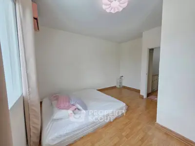 Spacious bedroom with minimalist decor and large window for natural light