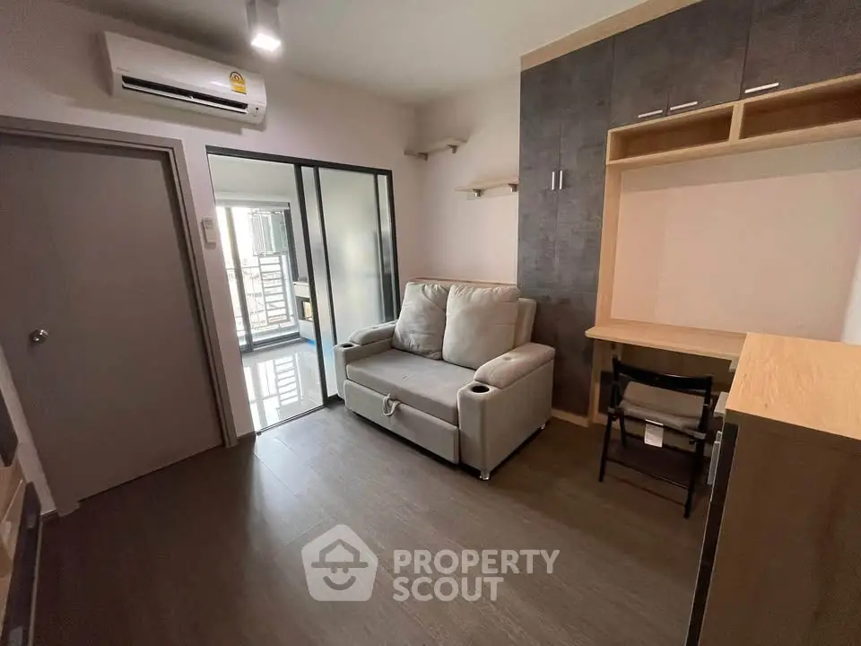 Modern living room with cozy sofa, air conditioning, and sleek built-in storage.